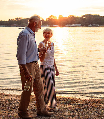 Senior Couple Walking on Beach With Glasses of Wine What is An Annuity California