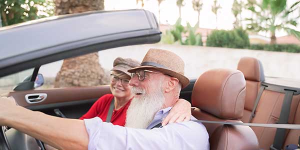 senior man in a convertible laughing and talking about retirement planning considerations