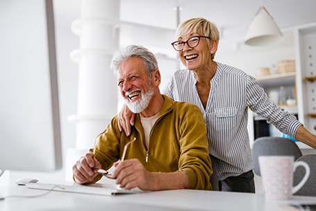 Smiling Senior Couple at Computer Desk What Is An Annuity California