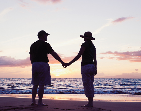 couple holding hands on beach at sunset benefits of fixed index annuities folsom ca