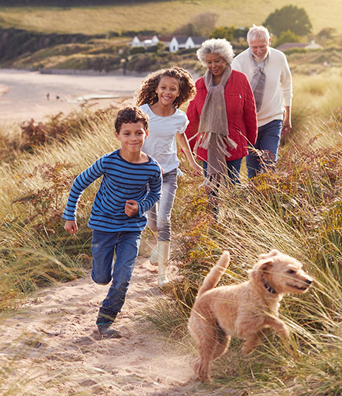 grandkids running on beach with grandparents and their pet dog what is indexed universal life insurance folsom ca